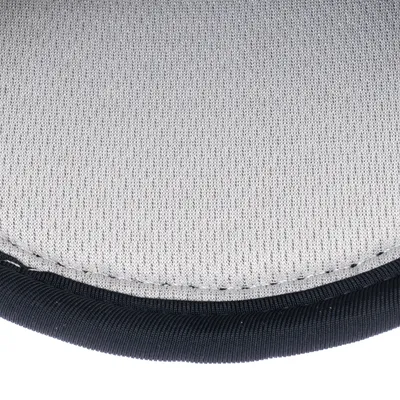 Gros plan sur une surface en tissu gris avec bordure noire, couture visible. Matériau textile, aucun logo ni texte apparent.