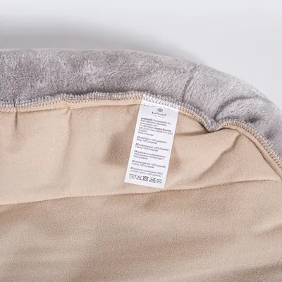 Product label showing care instructions and material composition, including washing symbols and text indicating 100% polyester in multiple languages.