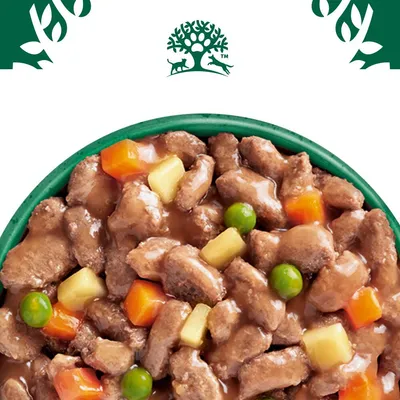 Close-up of wet food with meat pieces, peas, carrots and potatoes in sauce. At the top, a logo with tree, dog and cat.