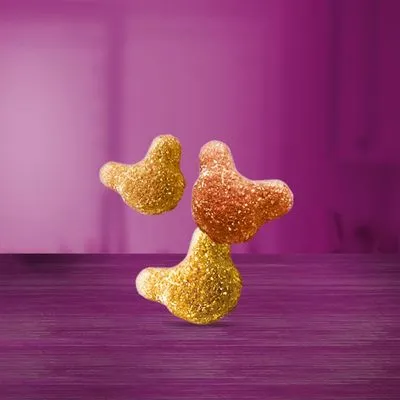 Drie brokjes in geel en oranje tinten, zonder zichtbare merknaam of verpakking, op een paarse ondergrond.