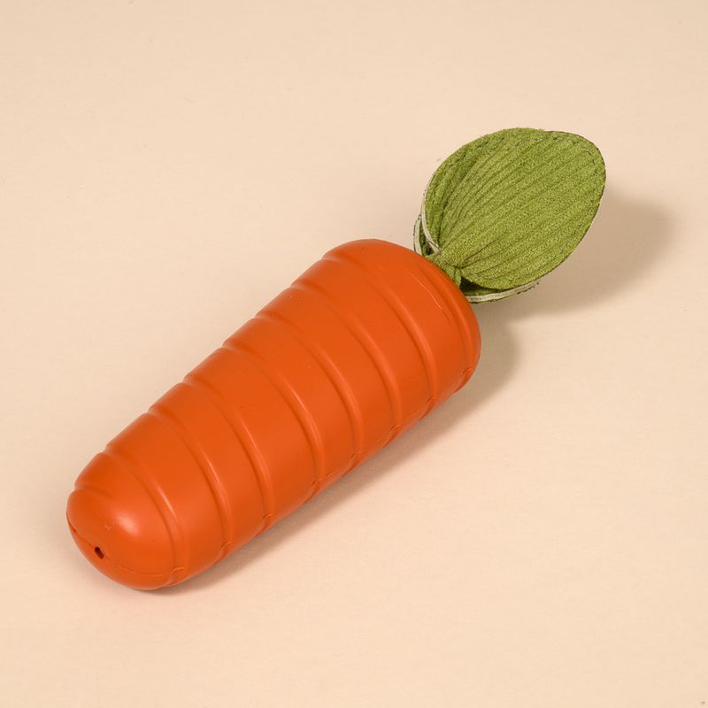 Spielzeug in Karottenform aus orangefarbenem Kunststoff mit grünem Stoffblatt.