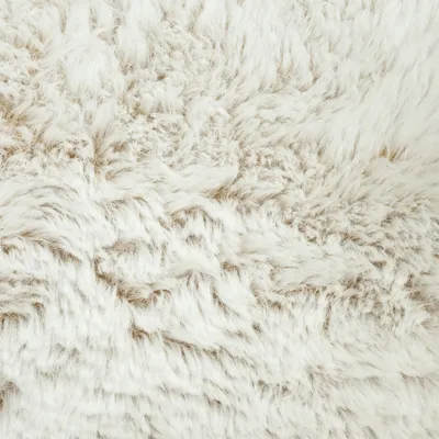Close-up van wit, pluizig imitatiebont met een licht beige ondertoon.