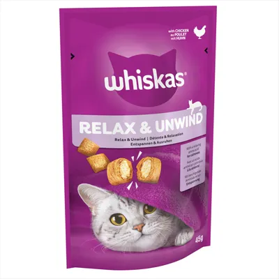 Whiskas Relax & Unwind treats with chicken, 45g pack. Contains relaxing amino acids for calmness. Image shows treat pieces and a cat under a blanket.