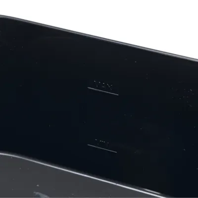 Repères de niveau gravés à l'intérieur d'un récipient en plastique noir, indications visibles : MAX et MIN.