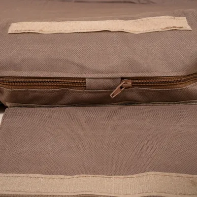 Nahaufnahme eines braunen Bezugs mit Reißverschluss und Klettverschluss, Materialstruktur deutlich sichtbar. Nahaufnahme eines braunen Bezugs mit Reißverschluss und Klettverschluss, Materialstruktur deutlich sichtbar.