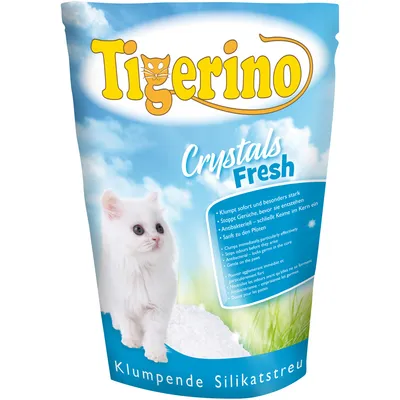 Envase de arena para gatos Tigerino Crystals Fresh, con imagen de un gato blanco y texto visible en alemán e inglés sobre características del producto. Klumpende Silikatstreu en la parte inferior.