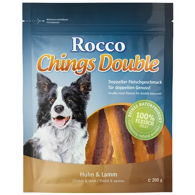 Rocco Chings Double Huhn & Lamm, 100% Fleisch Meat, pachet 200 g. Imagine cu un câine și fâșii de carne vizibile prin ambalaj. Text în germană și engleză pe ambalaj.