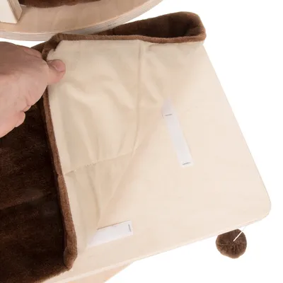 Pad moale din material textil bej și maro, detașabil cu benzi velcro, așezat pe o platformă din lemn deschis la culoare. Minge maro atașată dedesubt.