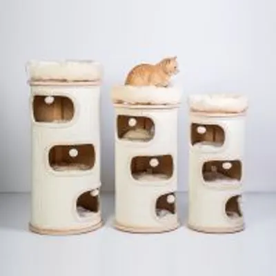 Tre tiragraffi cilindrici beige di diverse altezze con aperture e cuscini superiori, un gatto arancione seduto sul tiragraffi centrale.