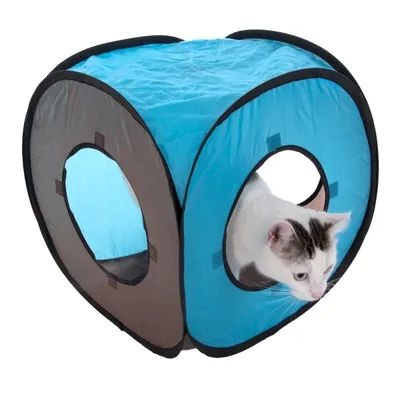 Blau-brauner Spielwürfel aus Stoff mit runden Öffnungen, Katze schaut durch eine Öffnung.