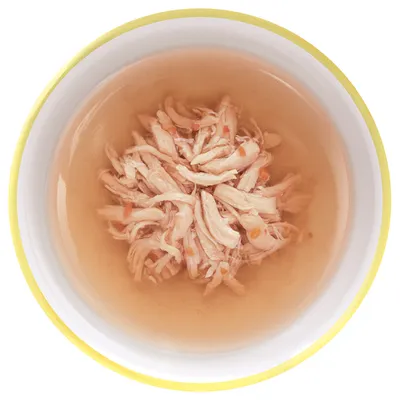 Миска с влажным кормом: кусочки мяса в бульоне, вид сверху. Без упаковки и видимых брендов.