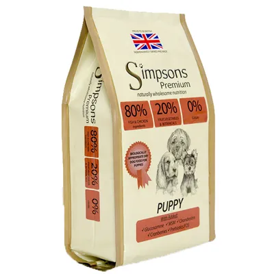 Simpsons Premium Puppy hundfoder. 80 % fisk & kyckling, 20 % frukt/grönsaker, 0 % spannmål. Brittisk flagga synlig. Text: Biologically appropriate dry dog food for puppies.