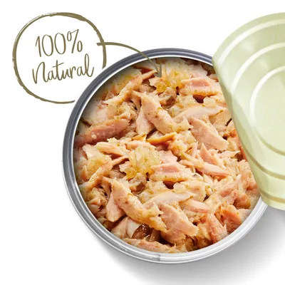 Открытая жестяная банка с кусочками мяса, видна надпись на английском: 100% Natural