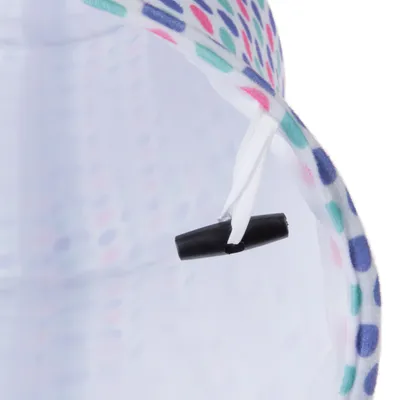 Detailný záber na bielu textilnú pásku s čiernym plastovým zapínaním, obklopenú farebným bodkovaným vzorom.