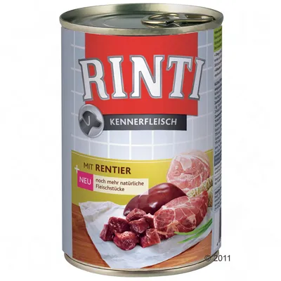 Lata de comida para perros Rinti Kennerfleisch, texto visible: Mit Rentier, neu noch mehr natürliche Fleischstücke. Imagen de trozos de carne cruda en la etiqueta.