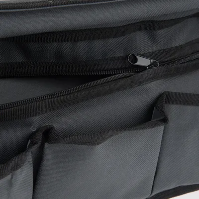 Close-up van een zwarte tas met ritssluiting en meerdere vakken van duurzaam materiaal.