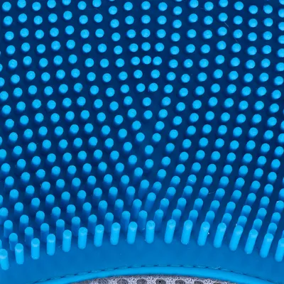 Nahaufnahme einer blauen Gummibürste mit weichen Noppen, geeignet für Fellpflege.