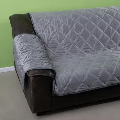 Graue gesteppte Sofadecke, passend für dunkle Ledersofas, schützt die Sitzfläche und Armlehnen.