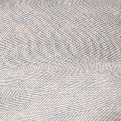 Nahaufnahme eines Stoffmusters mit Fischgrätenmuster in Blau und Beige.