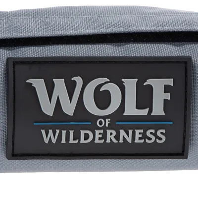 Wolf of Wilderness. Logo značky na šedém textilním pozadí.