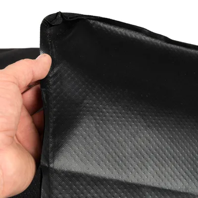 Detailný záber na čierny, štruktúrovaný povrch s rukou držiacou okraj. Materiál pôsobí robustne a vodeodolne.