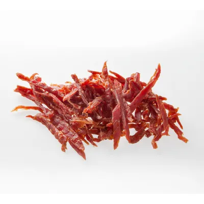 Лентички от сушено месо, нарязани на тънки ивици, без опаковка или видима марка. Видим цвят: червеникавокафяв.