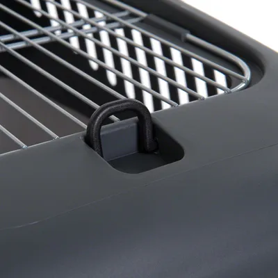 Detalje af grå transportkasse i plastik med metalgitter og sort håndtag eller fastgørelsesbøjle synlig på toppen.