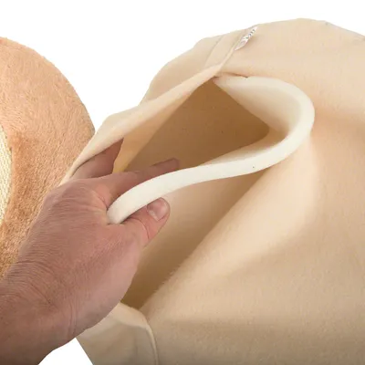 Hand showing the inside of a beige, padded pet bed with soft foam filling.