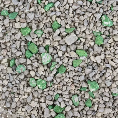 Närbild av grå och gröna granulatbitar, eventuellt kattsand eller liknande material.