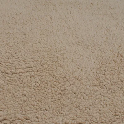Nahaufnahme von beigem, flauschigem Stoff mit strukturierter Oberfläche