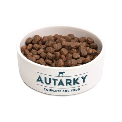 Bowl filled with brown kibble, labelled 'Autarky Complete Dog Food'.