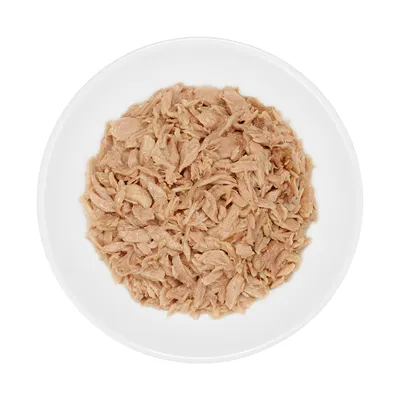 Hvid skål med strimlet, lyst kød, typisk vådfoder til kæledyr. Ingen synlige mærker eller tekst.