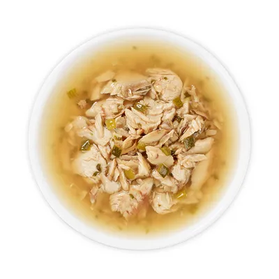 Close-up of a bowl with shredded chicken and vegetables in broth.