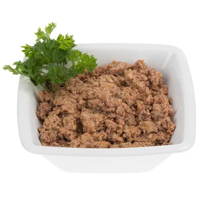 Schale mit feuchtem, braunem Tierfutter, dekoriert mit frischer Petersilie.