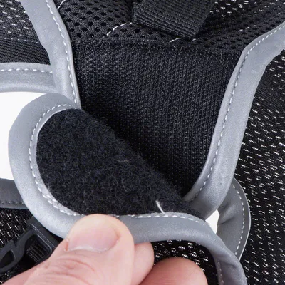 Nahaufnahme eines Klettverschlusses an einem schwarzen, atmungsaktiven Material mit grauen Nähten. Zeigt die Funktion des Verschlusses durch Handbewegung.