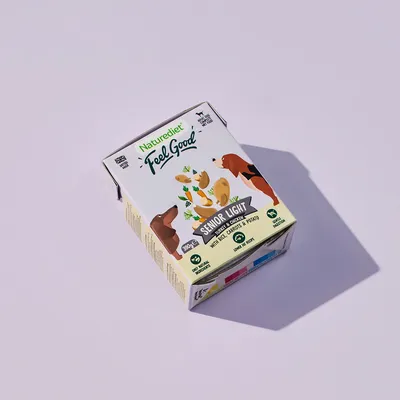 Box labelled 'Feel Good Senior Light' with chicken, carrots and potato, showing icons for gluten free, natural ingredients, and recyclable packaging.
