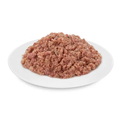 Zbliżenie surowego, rozdrobnionego mięsa na białym talerzu. Zdjęcie produktu dla karmy dla zwierząt.