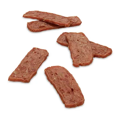 Tranches de friandises à mâcher pour animaux, aspect viande séchée, sans emballage visible, posées sur fond blanc.