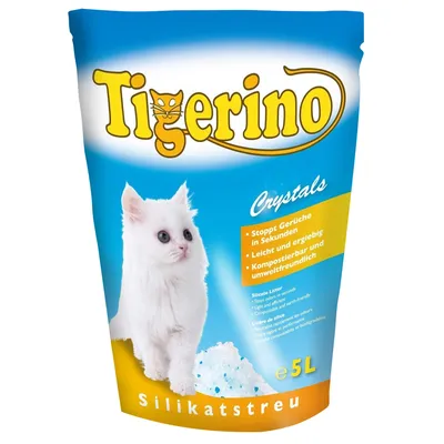 Tigerino Crystals silikátové stelivo pro kočky, 5 l. Text: Stoppt Gerüche in Sekunden, Leicht und ergiebig, Kompostierbar und umweltfreundlich. Bílá kočka a silikátové krystaly na obalu.