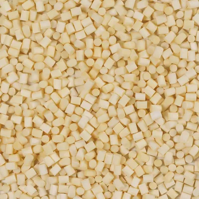 Nahaufnahme von kleinen, beige-farbenen Würfeln aus einem festen Material. Produktdetails nicht sichtbar.