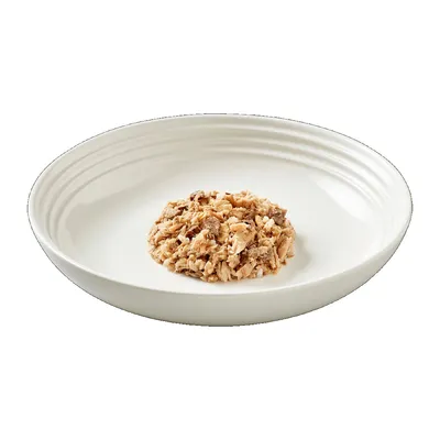 Порция консервирана храна с месо, сервирана в бяла керамична купа. Не се виждат марка или етикет.