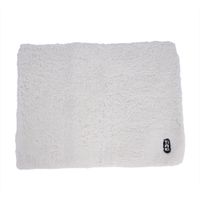 Tappetino bianco e soffice con logo TIEKI nell'angolo. Forma rettangolare, adatto come base o cuscino.