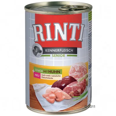 Консерва Rinti Kennerfleisch Senior. Видны кусочки мяса, надписи: SENIOR MIT HUHN, noch mehr natürliche Fleischstücke. Упаковка для корма с изображением мяса.