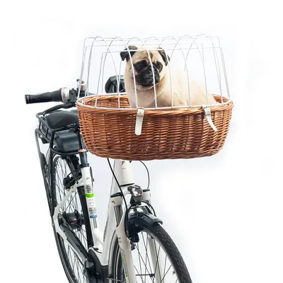 Cykelkurv af flettet træ med metalgitter, monteret på et cykelstyr. Kurven viser en hund som eksempel på brug.