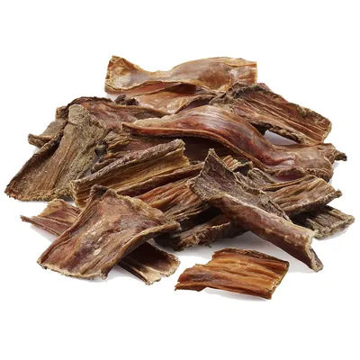 Sušené masové proužky, hnědé a nepravidelného tvaru, viditelné jako pamlsek nebo žvýkací produkt. Sušené masové proužky, hnědé a nepravidelného tvaru, viditelné jako pamlsek nebo žvýkací produkt.