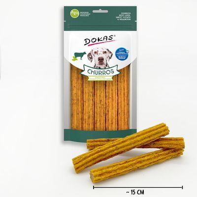 DOKAS Churros hondensnack, verpakking met zichtbare sticks. Tekst: 'CHURROS', 'BEEF LIVER, SWEET POTATO & MEADOW HAY'. Afmeting: circa 15 cm per stick.