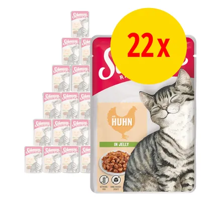 Schmusy kattmat med kyckling i gelé, 22 portionspåsar. Stor gul cirkel med röd text: 22x. Bild på nöjd katt och skål med mat synlig på förpackningen.