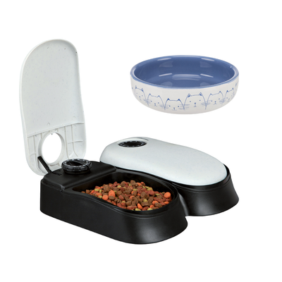 Gamelle en céramique avec motifs de têtes de chats et distributeur automatique de croquettes noir et blanc, symbole pourcentage rouge indiquant une offre ou promotion visible.