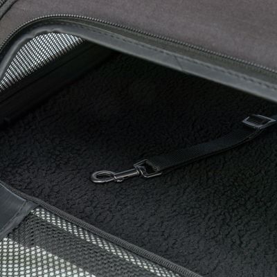 Binnenaanzicht van een transporttas met zwarte fleecelaag op de bodem en geïntegreerde veiligheidsgordel met metalen haak.