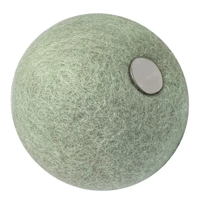 Balle ronde en feutre vert clair avec un disque métallique visible sur le dessus. Aucun texte ou marque apparente. Balle ronde en feutre vert clair avec un disque métallique visible sur le dessus. Aucun texte ou marque apparente.